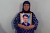 مادر شهید فرزاد, با تصویری از فرزند دلیر خود در آغوش