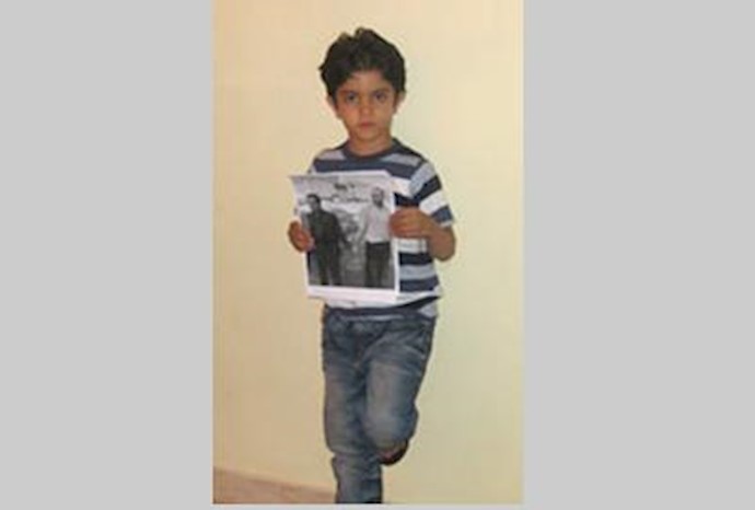 پارسا, کودک خردسال زندانی سیاسی محمد اولیایی با تصویری از پدر در دست