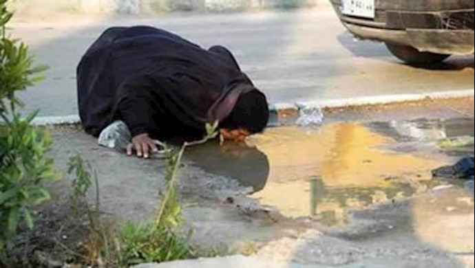 زنی در ایران در حال نوشیدن آب جمع شده روی زمین