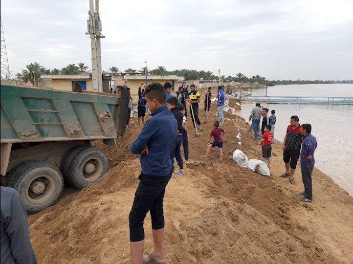 تلاش جوانان برای جلوگیری از ورود سیلاب به روستای بهور در شهرستان کارون
