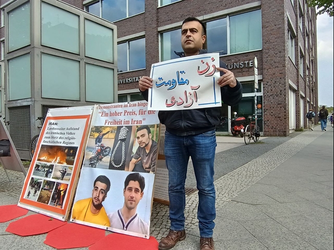 برلین - میز کتاب هواداران سازمان مجاهدین خلق ایران و هواداران مقاومت مقابل دانشگاه پلی‌تکنیک با شعار زن مقاومت آزادی