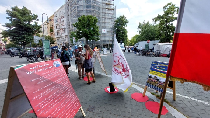 برلین - برگزاری میز کتاب و نمایش تصاویر شهیدان در همبستگی با قیام سراسری توسط ایرانیان آزاده - ۱۹خرداد