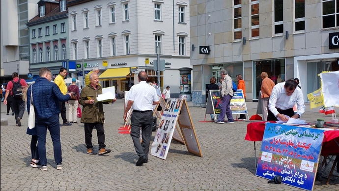 برلین - برگزاری میز کتاب و نمایش تصاویر شهیدان در همبستگی با قیام سراسری - ۱۸خرداد