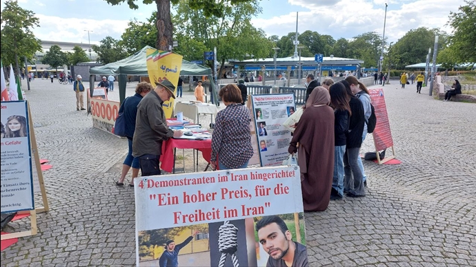برلین - برگزاری میزکتاب و نمایش تصاویر شهیدان در همبستگی با قیام سراسری توسط ایرانیان آزاده - ۲۵خرداد