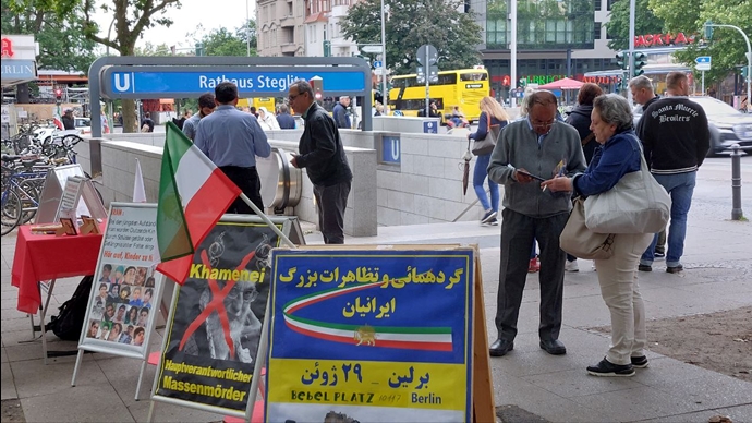 برلین - برگزاری میز کتاب و نمایش تصاویر شهیدان در همبستگی با قیام سراسری توسط ایرانیان آزاده - ۲۵خرداد
